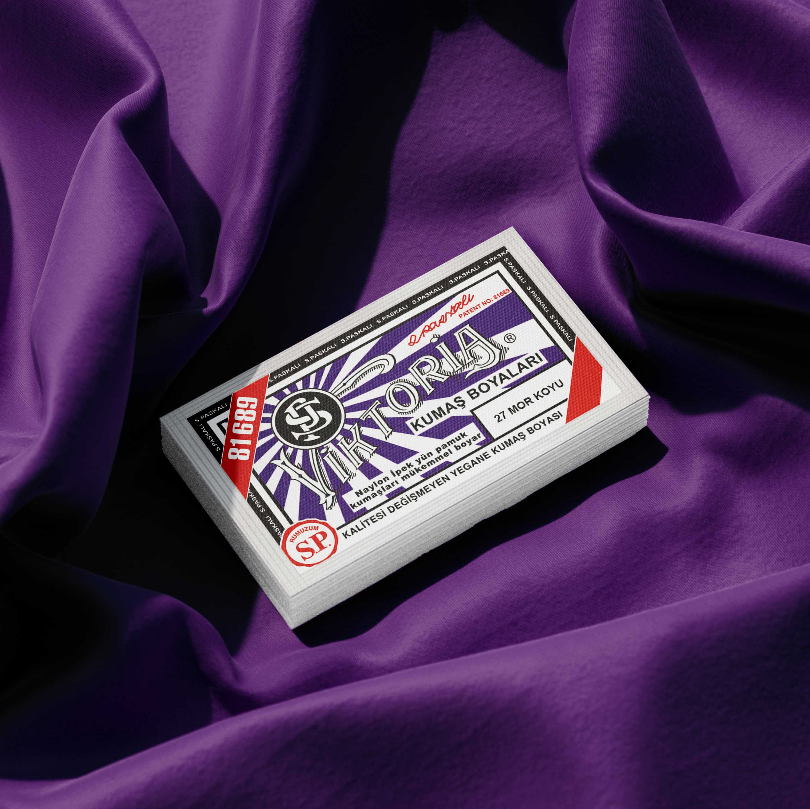 Pack of dark purple fabric dye placed on a vibrant purple fabric background